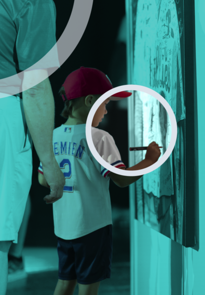 Child drawing on interactive activation wall with adult standing nearby