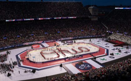 NHL Stadium Series 2025 at Ohio Stadium pregame ceremony with marching band forming Ohio on ice, outdoor hockey rink setup, and sold-out stadium crowd